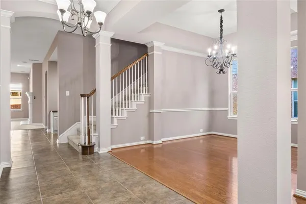 an empty room with chandelier and windows