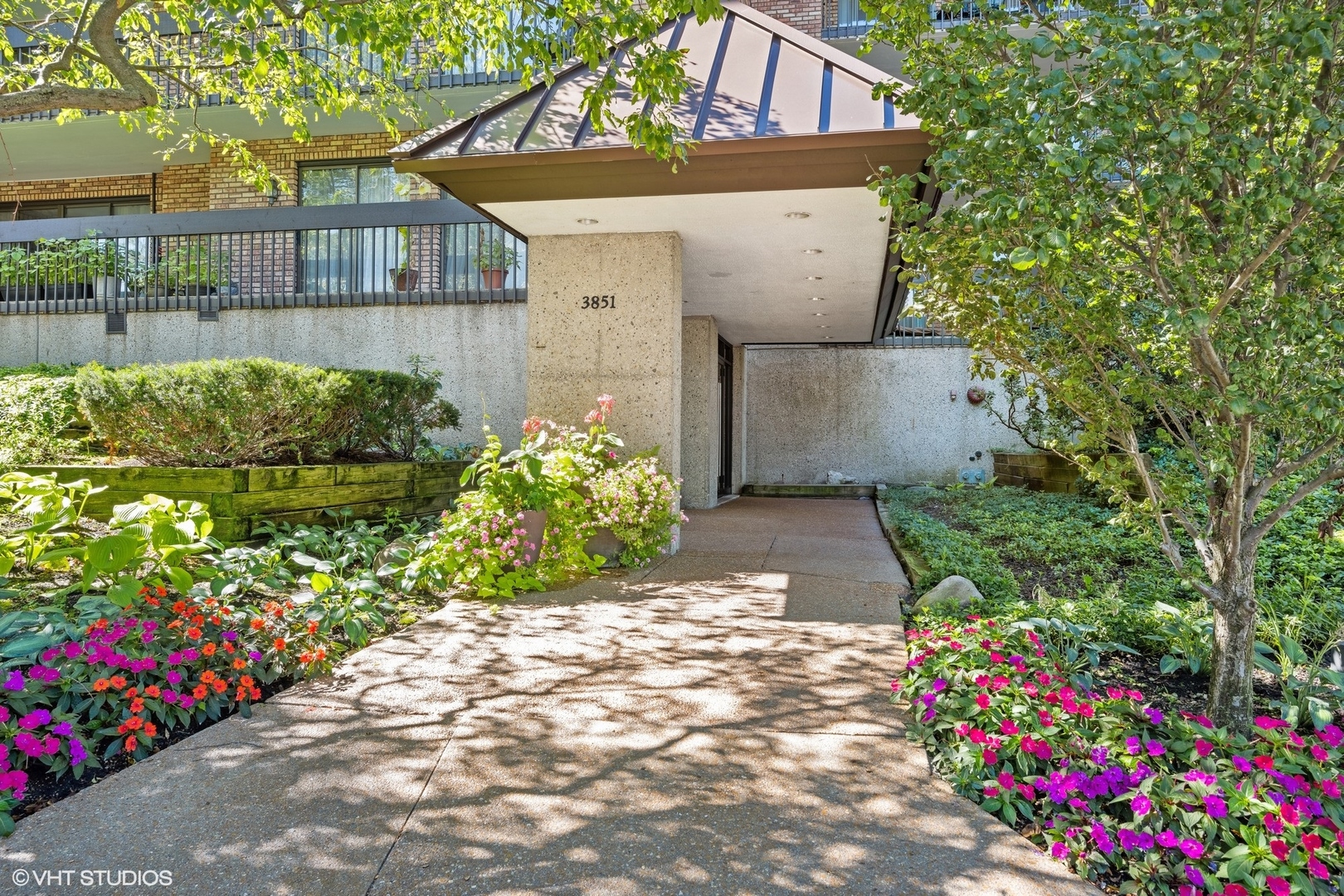 3851 Mission Hills Road, Unit 203 Northbrook, IL 60062 - Photo 2 of 21 a front view of a house with a yard and fountain