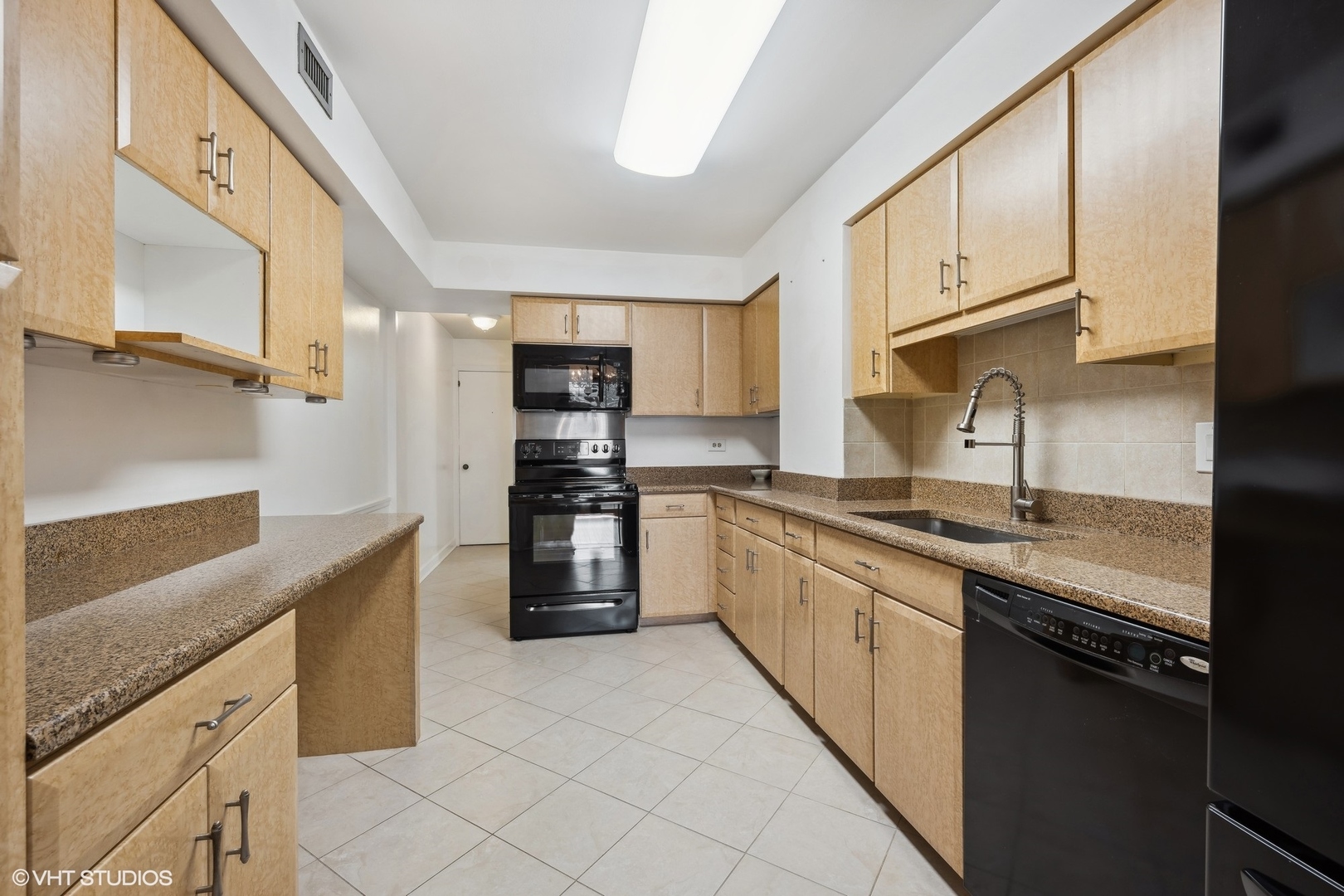 3851 Mission Hills Road, Unit 203 Northbrook, IL 60062 - Photo 6 of 21 a kitchen with stainless steel appliances granite countertop a sink and dishwasher a refrigerator with wooden cabinets