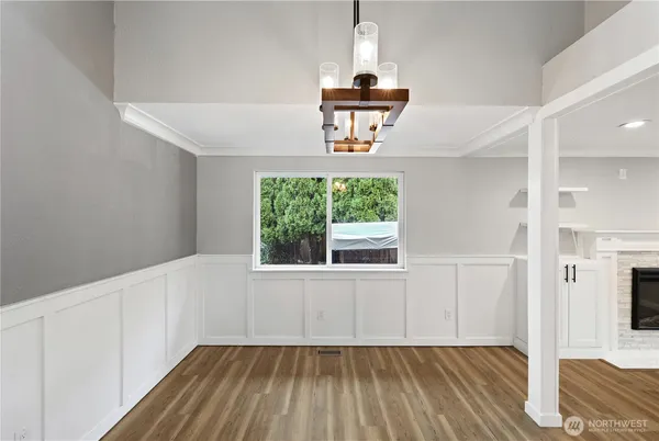 a kitchen with a sink a stove a refrigerator and white cabinets with wooden floor