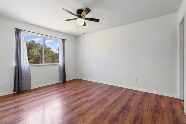 a view of an empty room with wooden floor