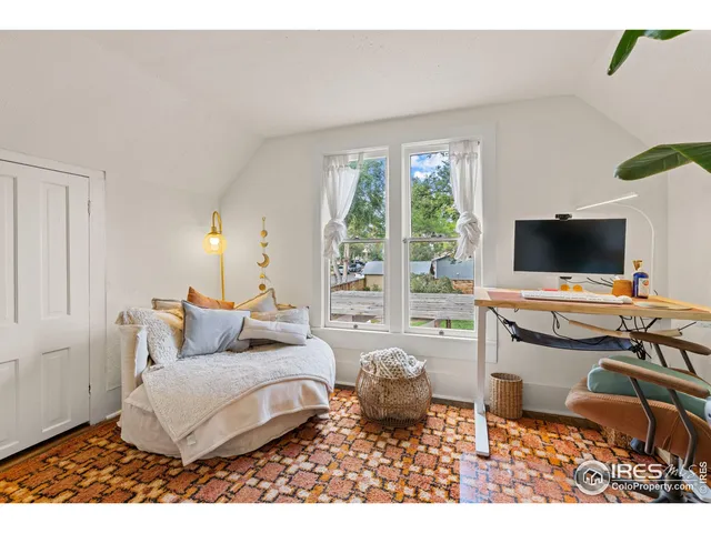 a bedroom with a bed table flowerpot and a potted plant