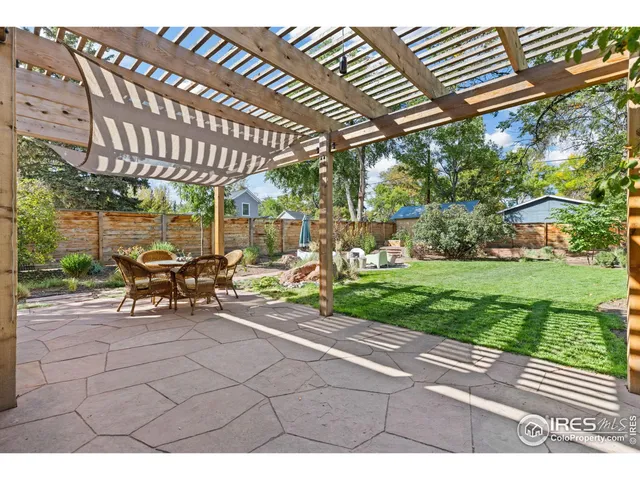 a view of a patio with a table and chairs under an umbrella