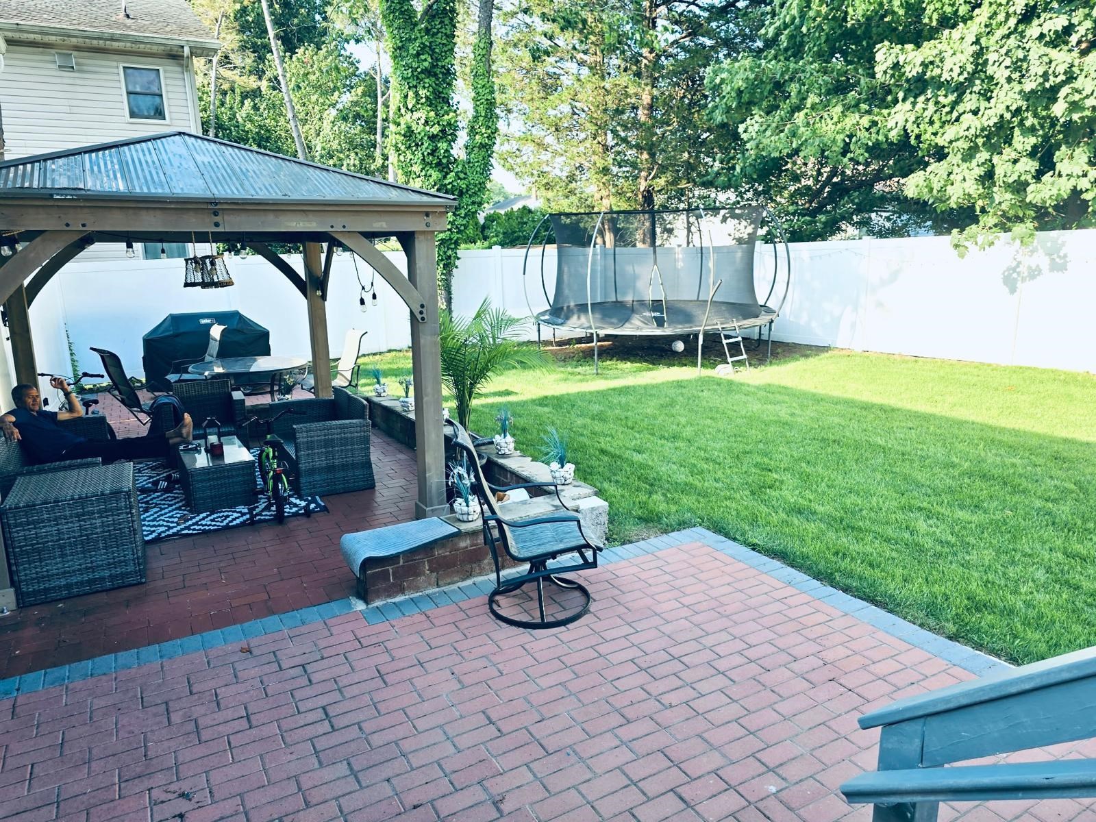 53 Harrison Street Dumont, NJ 07628 - Photo 27 of 28 a view of backyard with wooden fence and a table and chairs