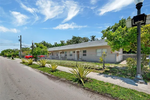 a view of a house with wooden fence next to a road