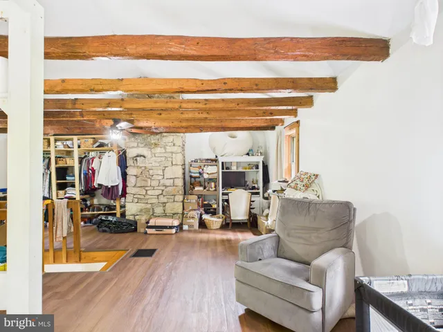 a living room with furniture a wooden floor and next to a window