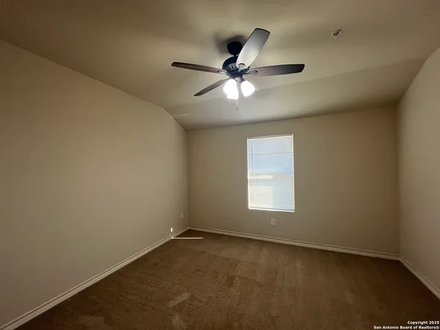 an empty room with a window and a fan