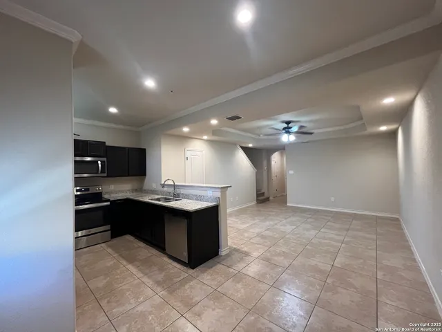 a view of kitchen with kitchen island stainless steel appliances sink cabinets and stove top oven