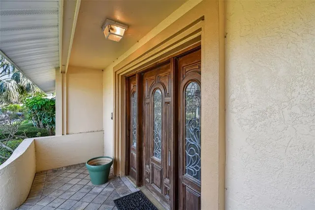 a front view of a house with garden and trees