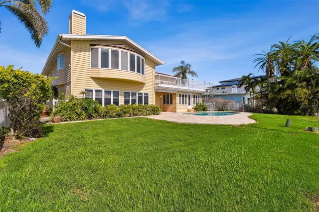 an aerial view of ocean and residential houses with outdoor space