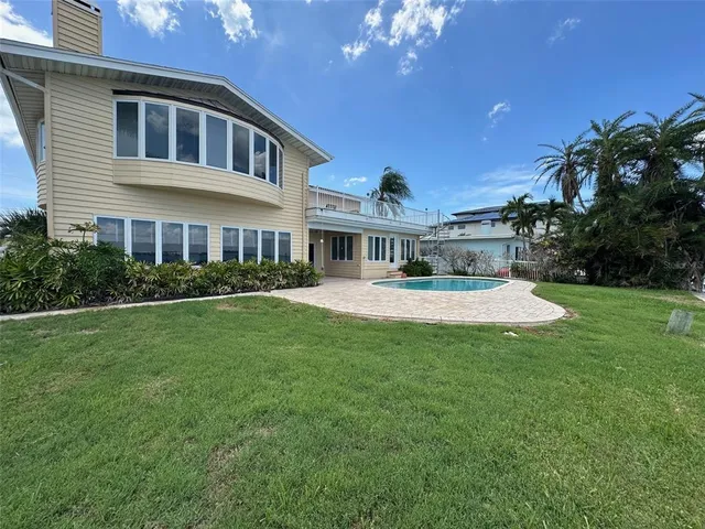 a front view of a house with a garden and trees