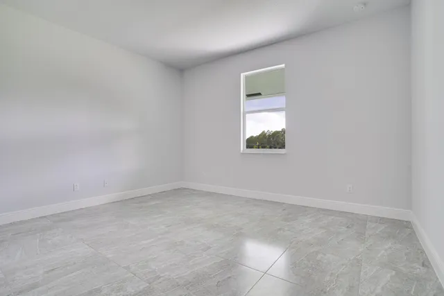 an empty room with window and mirror