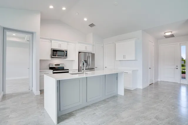 a kitchen with white cabinets and stainless steel appliances