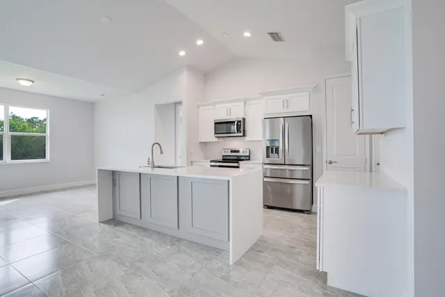 a kitchen with white cabinets and stainless steel appliances