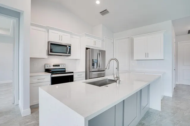 a kitchen with stainless steel appliances a stove microwave and sink