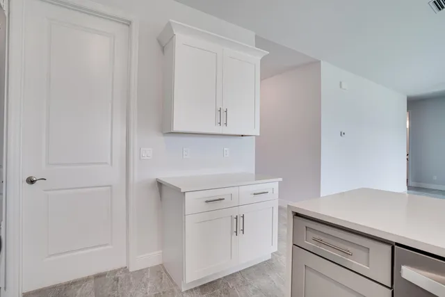 a kitchen with white cabinets and white appliances