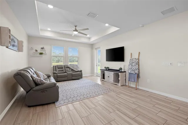 a living room with furniture flat screen tv and wooden floor
