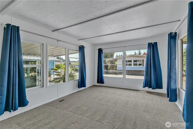 a view of an empty room with a fireplace and a large window