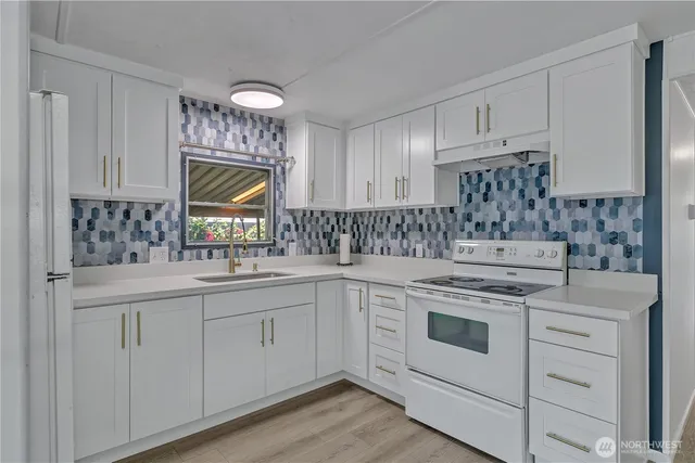 a kitchen with white cabinets appliances and a sink