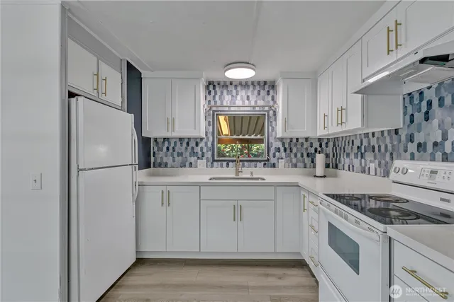 a kitchen with granite countertop a sink stove and refrigerator