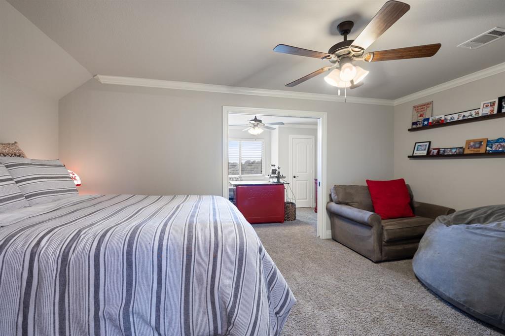 2103 Cash Point Court Granbury, TX 76049 - Photo 27 of 38 a bedroom with bed and a chandelier