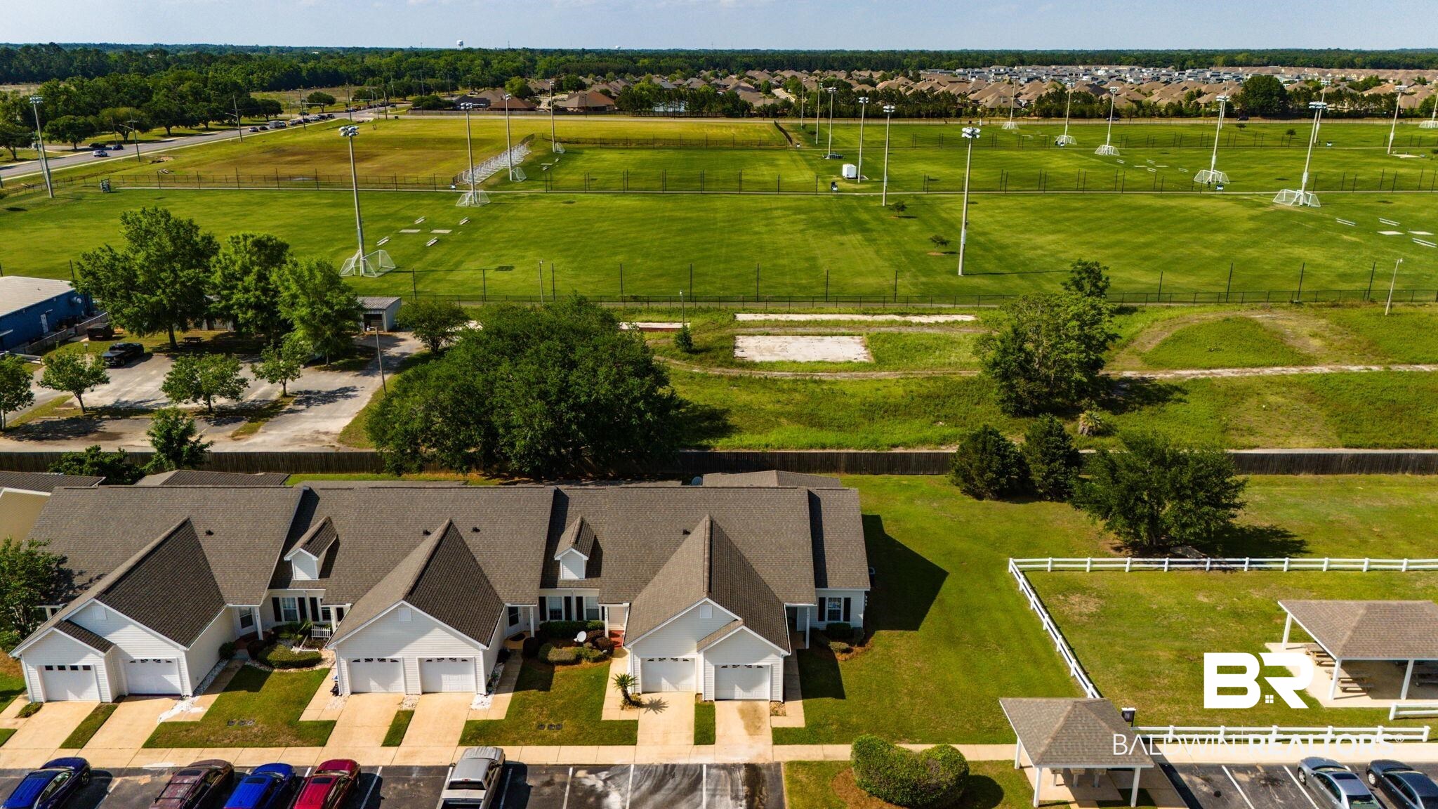 2651 South Juniper Street, Unit 705 Foley, AL 36535 - Photo 31 of 37 Residential structures featuring light-colored siding, dark shingle roofs, attached garages, and individual walkways