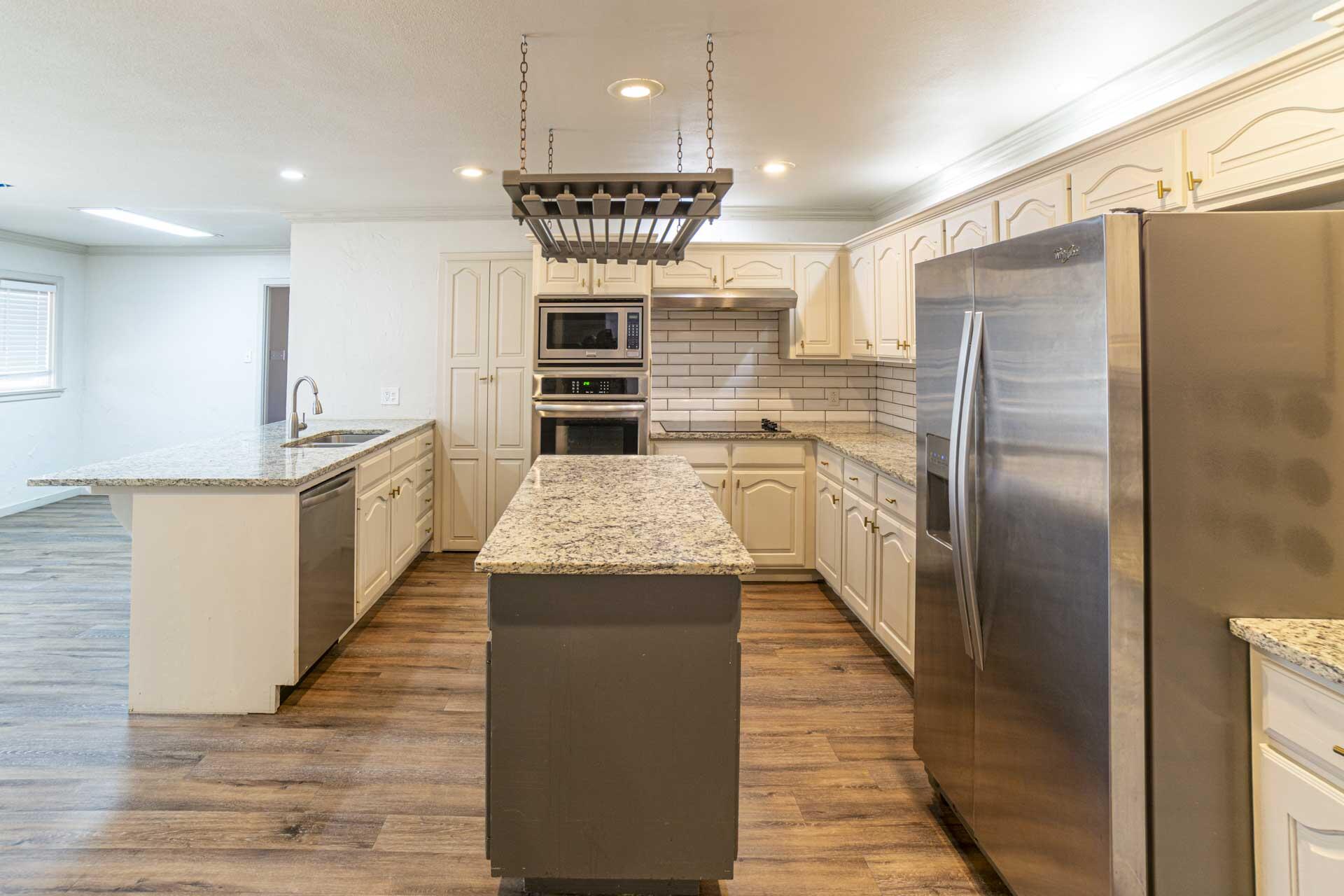 2136 57th Street Lubbock, TX 79412 - Photo 11 of 41 a kitchen with kitchen island a counter top space a sink appliances and cabinets