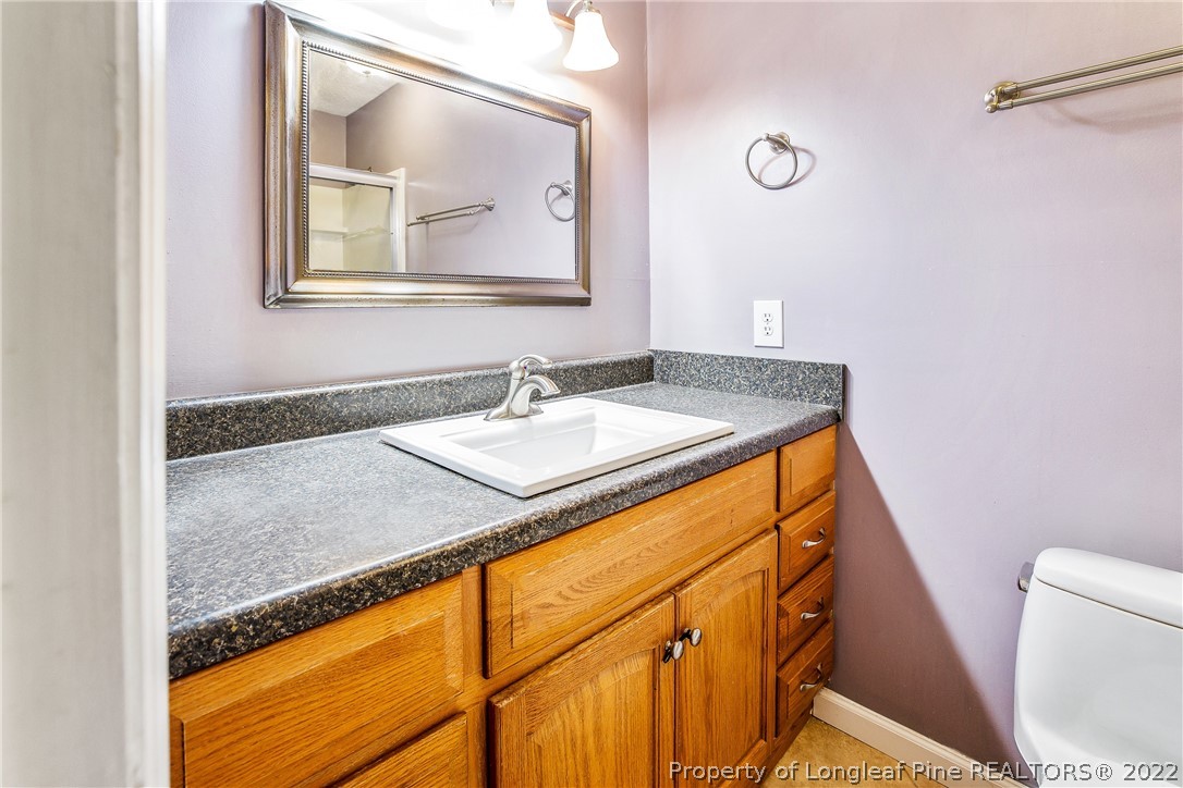 595 Winding Creek Road, Unit B Fayetteville, NC 28305 - Photo 12 of 17 a bathroom with a granite countertop sink and a mirror