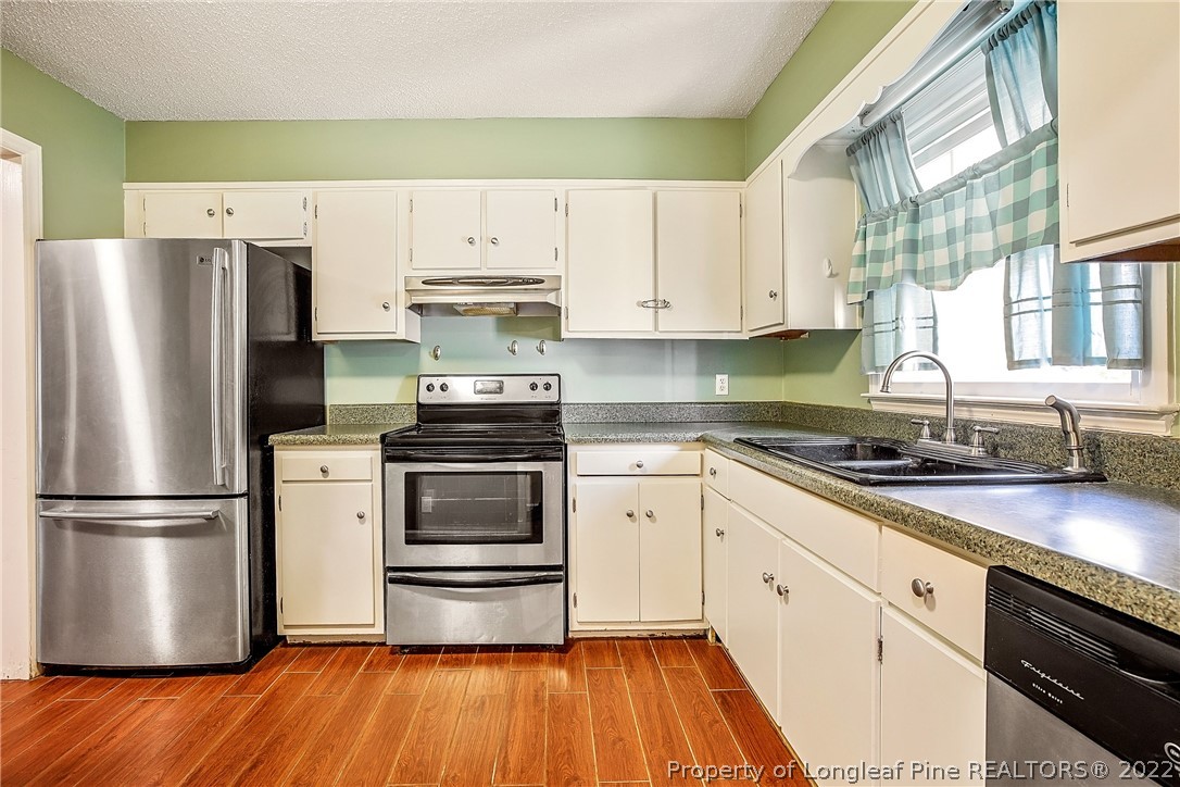 595 Winding Creek Road, Unit B Fayetteville, NC 28305 - Photo 6 of 17 a kitchen with granite countertop a refrigerator stove and white cabinets