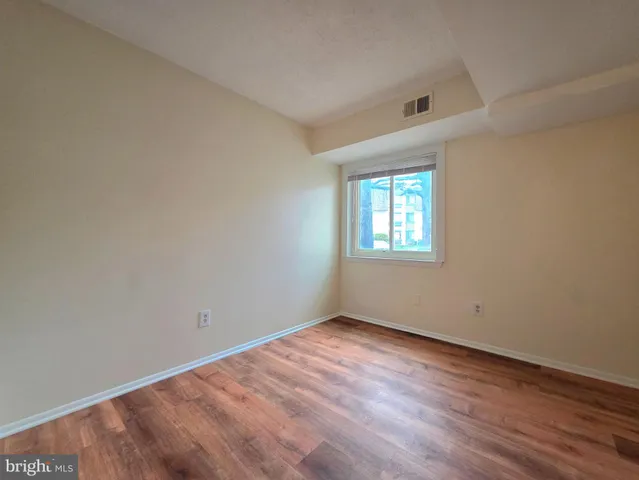 a view of room with window and wooden floor