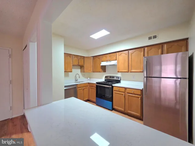 a kitchen with a stove top oven cabinets and stainless steel appliances