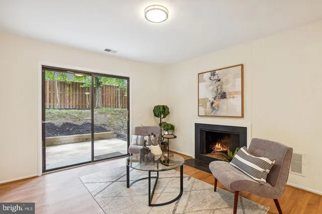 a living room with furniture a floor to ceiling window and a fireplace