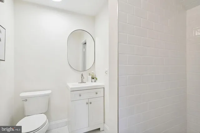 a bathroom with a toilet sink vanity and mirror