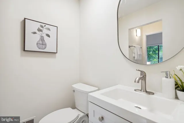 a bathroom with a toilet a sink and mirror