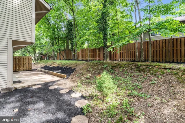 a view of a backyard with wooden fence