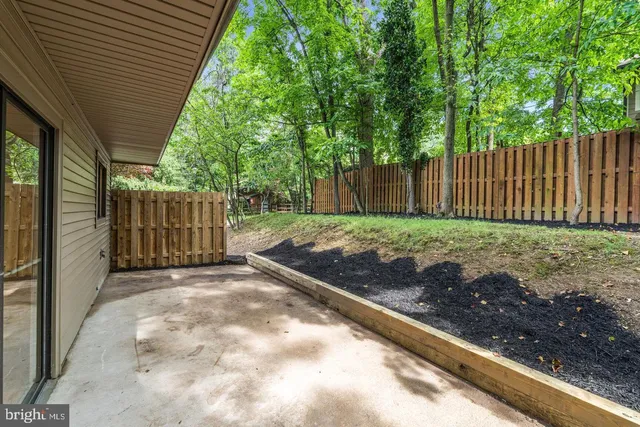 a view of a backyard with wooden fence