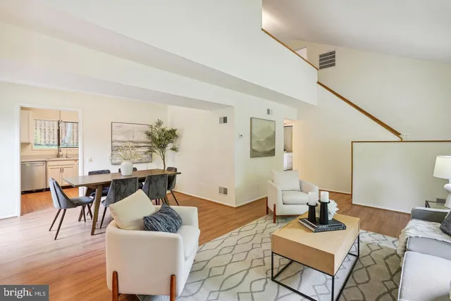 a living room with furniture a dining table and a potted plant