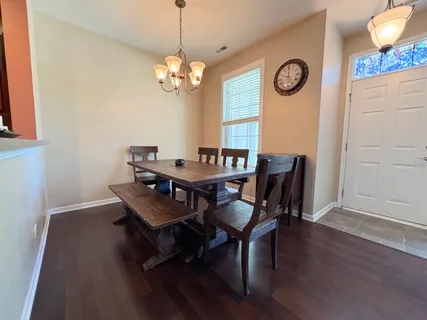 a view of a dining room with furniture wooden floor and a clock