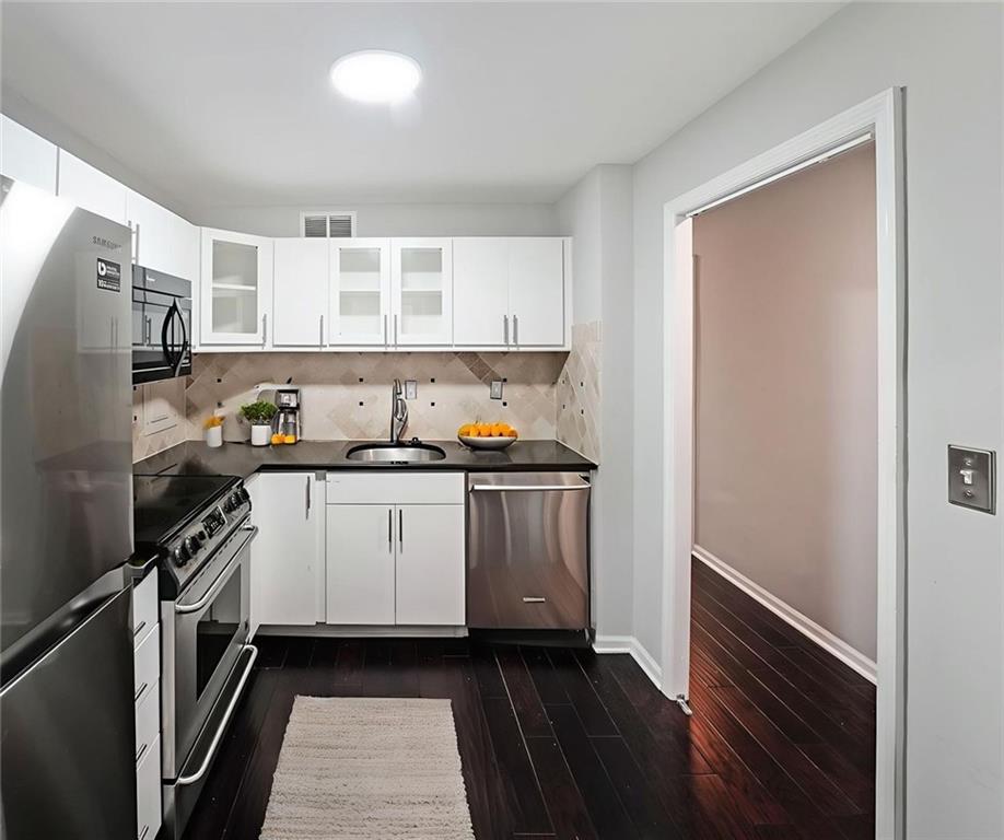 3060 Pharr Road Northwest, Unit 114 Atlanta, GA 30305 - Photo 4 of 16 a kitchen with a refrigerator and a stove
