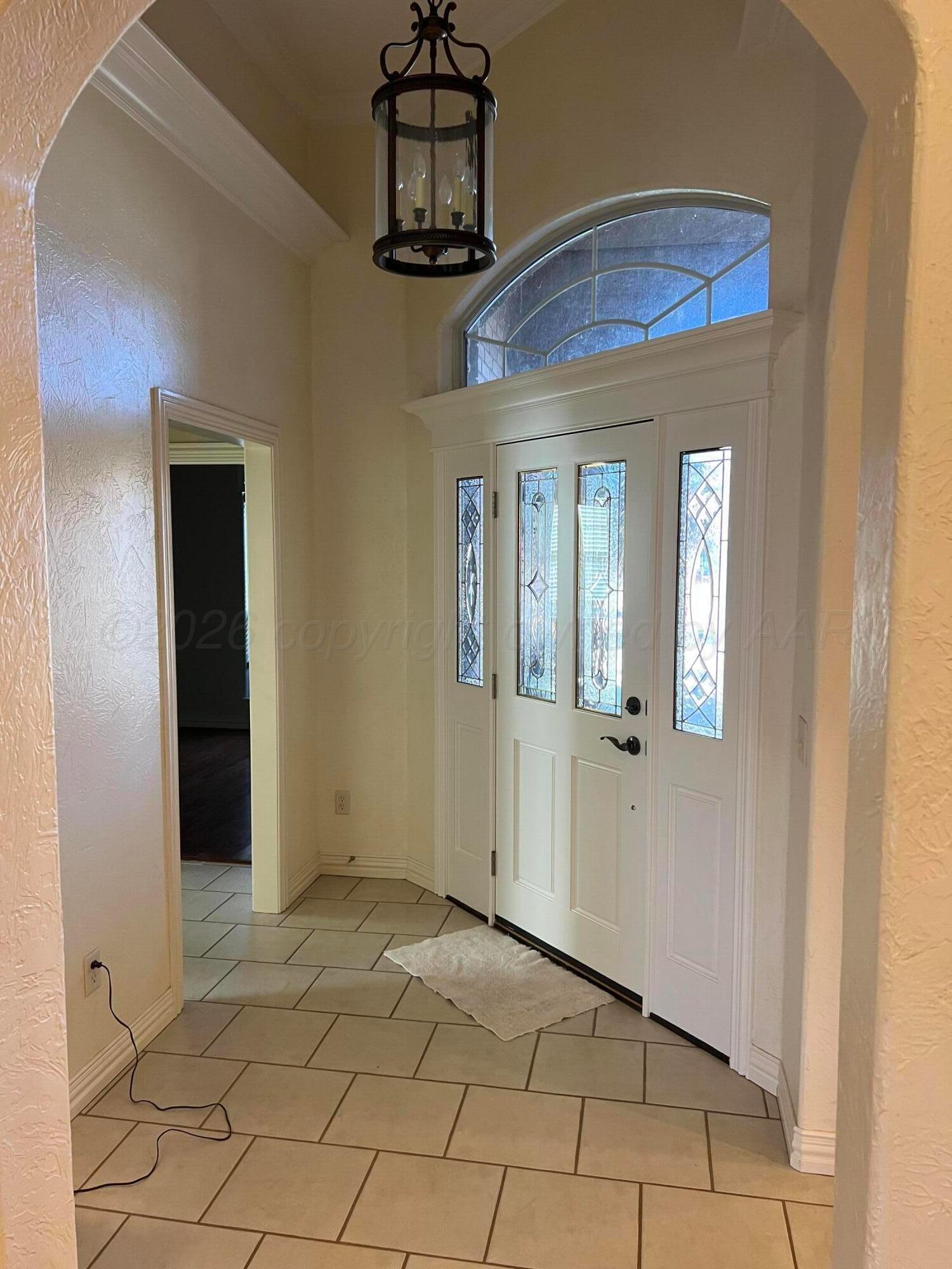 8405 Addison Drive Amarillo, TX 79119 - Photo 2 of 18 a view of a hallway with wooden floor and chandelier