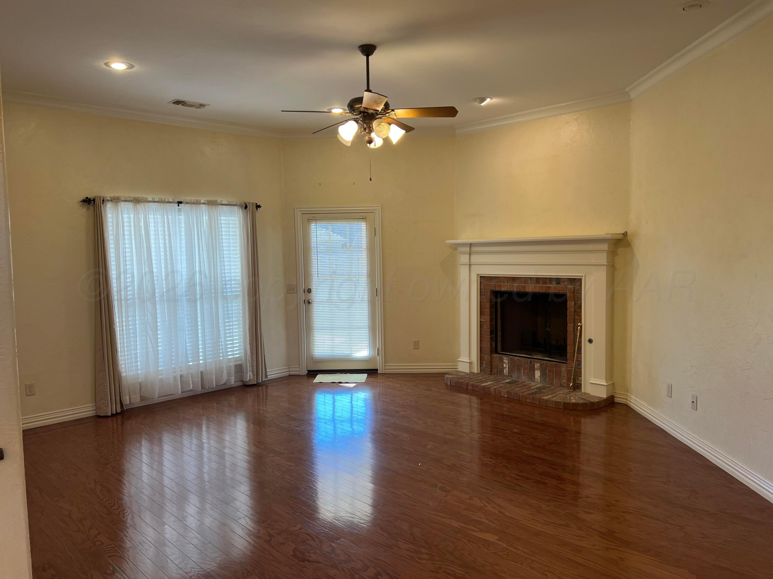 8405 Addison Drive Amarillo, TX 79119 - Photo 6 of 18 a view of an empty room with wooden floor and a fireplace