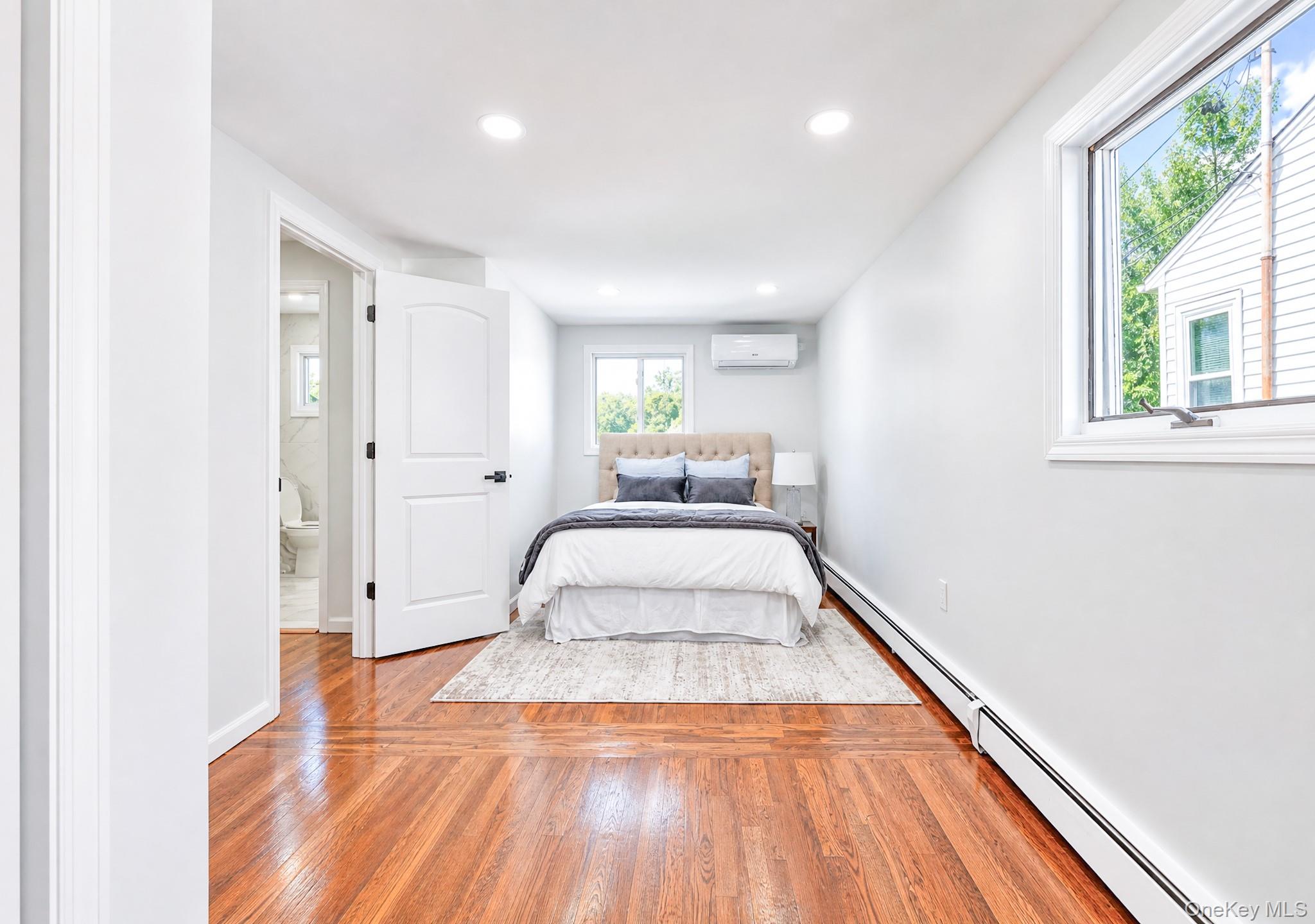 61 Cheshire Road Bethpage, NY 11714 - Photo 11 of 25 Bedroom featuring wood-finish flooring, recessed lighting, and a split-unit air conditioning system