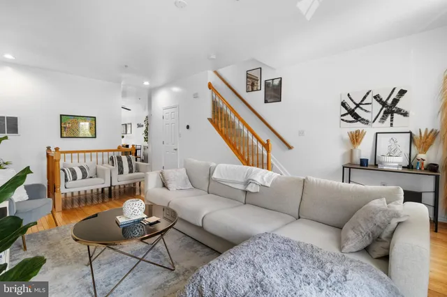 a living room with furniture and a wooden floor