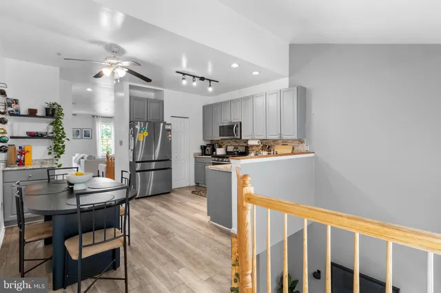 a kitchen that has a table chairs stainless steel appliances and cabinets