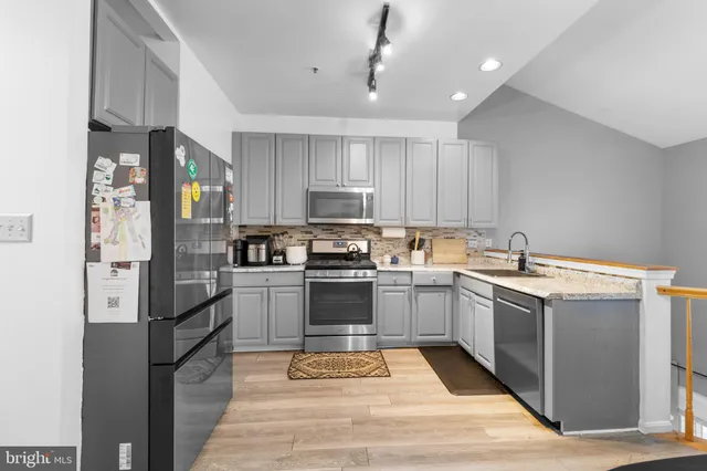 a kitchen with a sink stainless steel appliances and cabinets