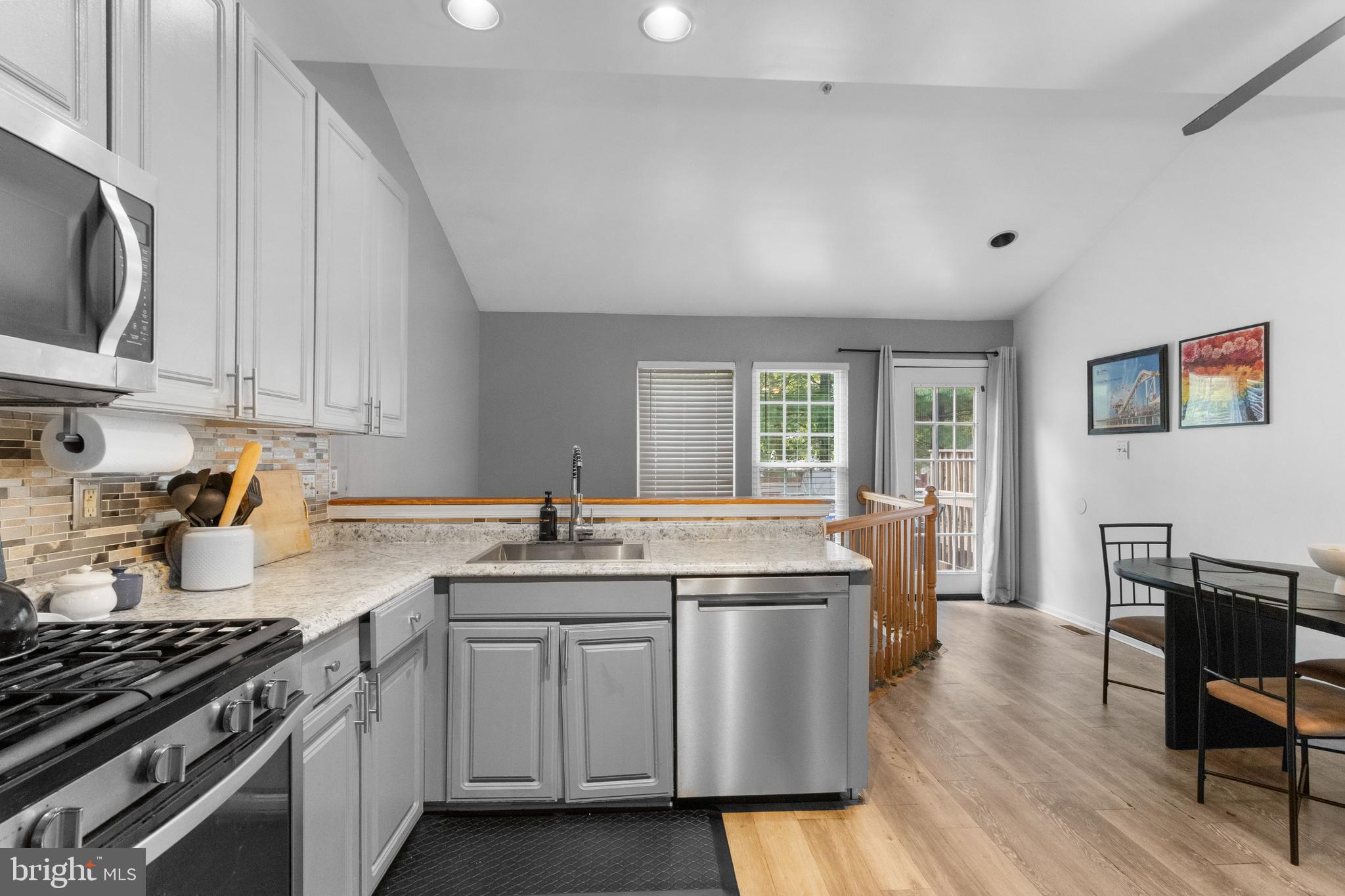 13 Bank Spring Court Owings Mills, MD 21117 - Photo 17 of 50 a kitchen with stainless steel appliances a sink dishwasher stove and wooden cabinets