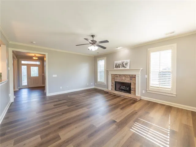a view of an empty room with a fireplace and a window