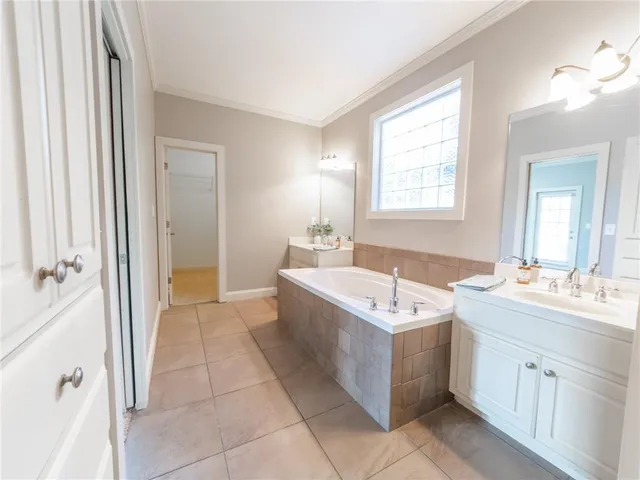 a bathroom with a tub sink and mirror