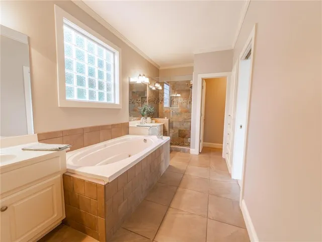 a large bathroom with a tub sink and mirror