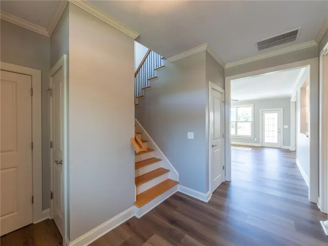 a view of a hallway with wooden floor and entryway